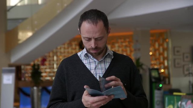 tourist reads an information booklet stand near the hotel
