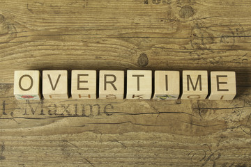 overtime word on cubes on wooden background