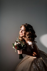 portrait of a bride in a beautiful dress. A bouquet in hand. hard light. 