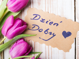 Polish words Good morning and bouquet of tulips on wooden background