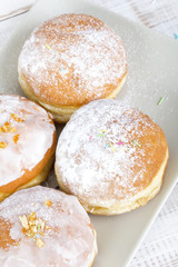 donuts with frosting and powdered sugar on a platter