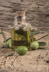 Unripe olives and olive oil on wooden table