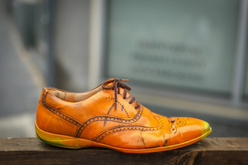 An old orange shoe on a wooden plank