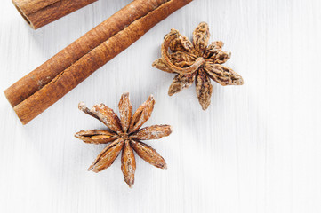 Top view: anise stars and cinnamon sticks on white wooden surface