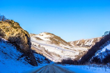 Fototapeta na wymiar дорога в горном ущелье, скалы, снежная зима