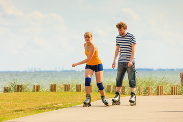Young couple on roller skates riding outdoors