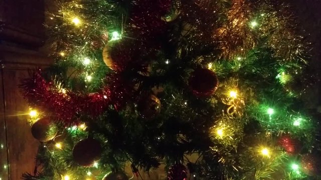 The multicolored garland flashing bright lights on the Christmas tree