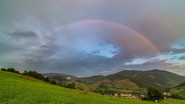 Double Rainbow over Green Meadow and Rural Landscape with Cloudy Sky Time Lapse