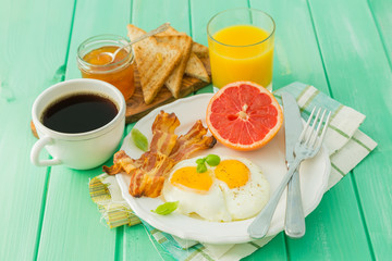 Summer breakfast - eggs, bacon, toast, jam, coffee, juice
