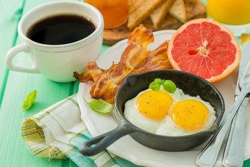 Summer breakfast - eggs, bacon, toast, jam, coffee, juice