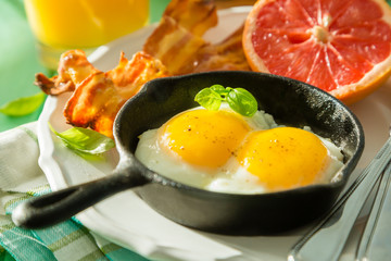 Summer breakfast - eggs, bacon, toast, jam, coffee, juice