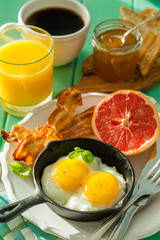 Summer breakfast - eggs, bacon, toast, jam, coffee, juice