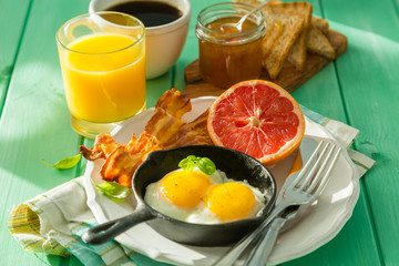 Summer breakfast - eggs, bacon, toast, jam, coffee, juice