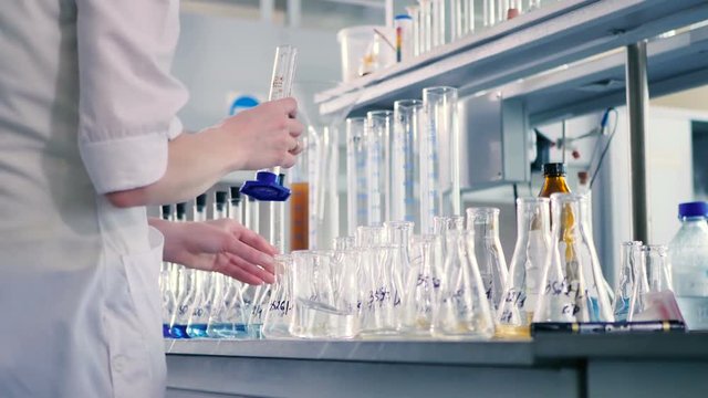 The woman pours water into the measuring glass.