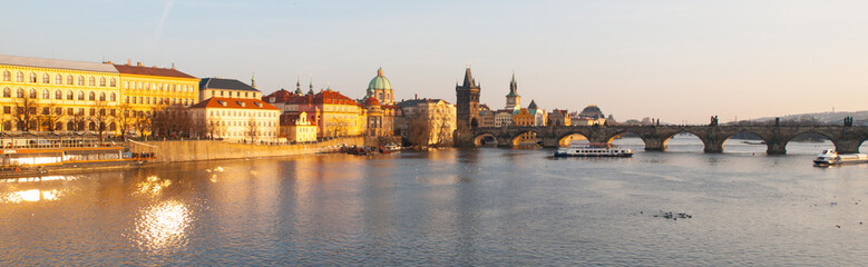 Obraz na płótnie Canvas Prague Evening. Towers of Old Town and Charles Bridge over Vltava River illuminated by orange sunset. UNESCO World Heritage Site. Prague, capital city of Czech Republic, Europe. Panoramic view.