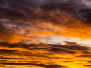Dramatic golden sky with illuminated clouds at evening sunset time.