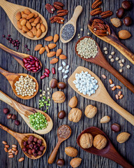 Various legumes and different kinds of nutshells in spoons. Waln