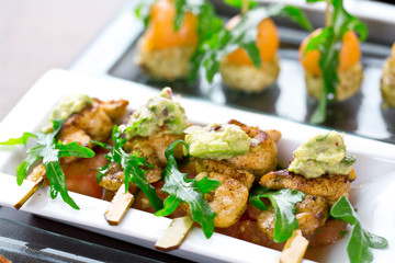 set of finger food - chicken skewers with guacamole