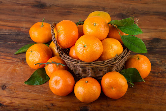 mandarin orange fruits in basket on old wooden table