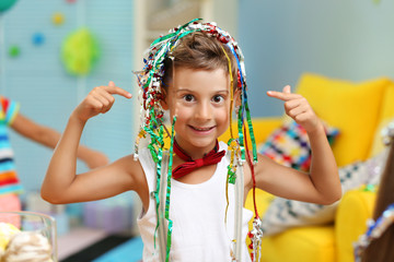 Birthday celebrating. Funny boy with shiny streamer on head