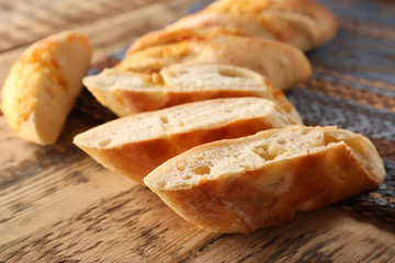Slice baguette on wooden table closeup