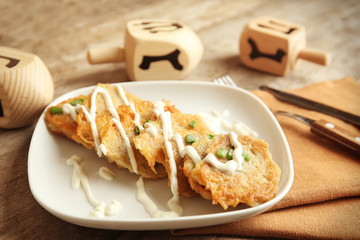 Plate with tasty potato pancakes for Hanukkah on wooden table, closeup