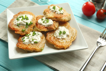 Plate with tasty potato pancakes for Hanukkah on wooden table