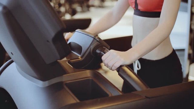 Fit women goes on treadmills in modern gym or fitness center. Close up