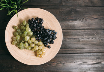 dark and white grapes on a pink plate, free place