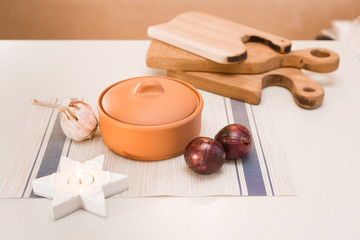 clay pot, garlic and red onions on the table

