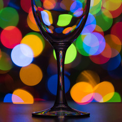 Wine glass on dark multi-colored background