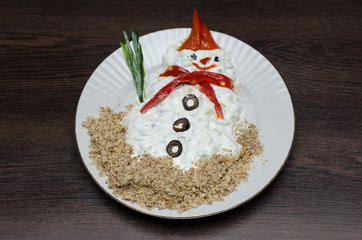 Funny snowman made of white souce in plate