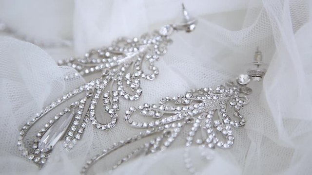 Beautiful wedding bride earrings on the veil closeup