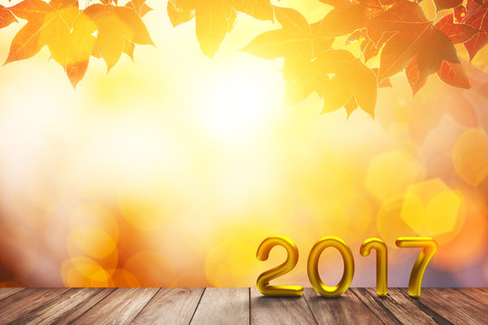 Gold 2017 Text on old wood on red maple in autumn and bokeh light background for Happy New Year Concept.