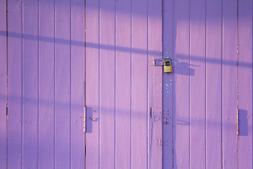 Wooden purple door with lock in the morning.