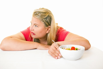 Obraz na płótnie Canvas Woman looking away from bowl of healthy salad.