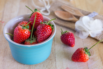 strawberry with fork and spoon on wooden background