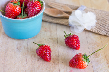 strawberry with fork and spoon on wooden background