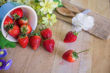 strawberry with fork and spoon on wooden background