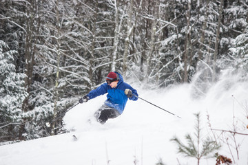 Skiing Teen in Blue Jacket Spraying Powder
