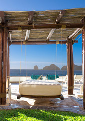 Fototapeta na wymiar Beach chairs and swinging bamboo bed on the beach 