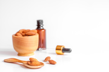 cosmetic almond oil in glass bottle on white background