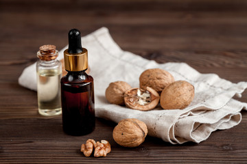 cosmetic and therapeutic walnut oil on dark wooden background