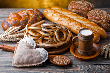 Milk in a vessel in a composition with bread on an old background