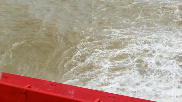Red Wooden Paddle-wheel Turning at the Back of an Historic Steamboat on Mississippi River Tilting Up Revealing the City of New Orleans in the Distance