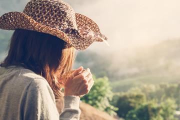 Woman holding a cup of coffee with beautiful landscape