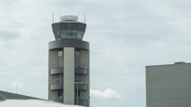 Air Traffic Control ATC Tower at Louis Armstrong New Orleans International Airport with Communication Antennae and Spinning Radar on a Cloudy Overcast Day in Louisiana