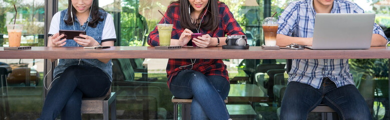 three people using smartphone, tablet, and laptop in coffee shop © stnazkul