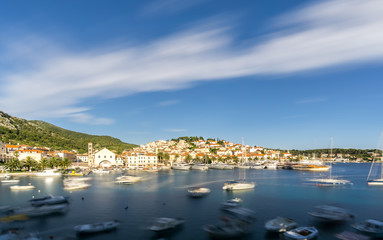 Naklejka na ściany i meble The blurred movement of boats shows the busy port in Hvar Town in Croatia in summer, a popular travel destination in Europe.