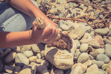 Hands of a young girl holding pieces of wood and making fire on